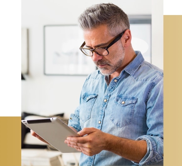 Man holding and looking at tablet.