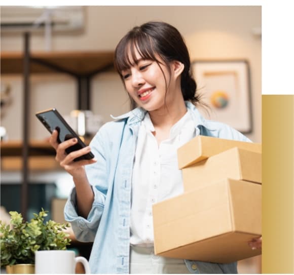 Woman holding boxes and a cell phone.