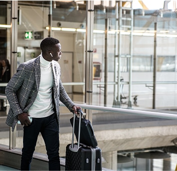 Business man walking through airport with luggage.