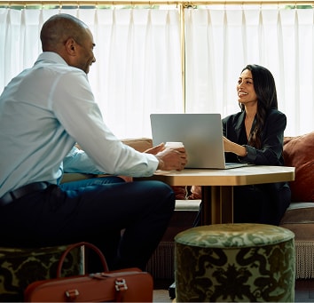 Two business people sitting together in a lounge.