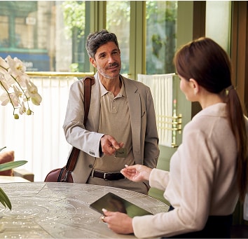 Man handing the Business Platinum Card to a hotel concierge.
