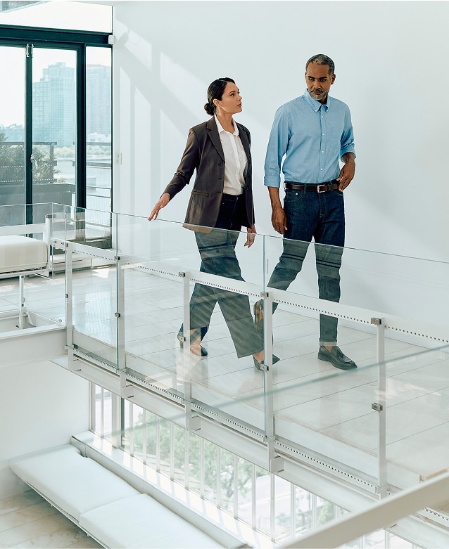 Two coworkers walking in hallway.