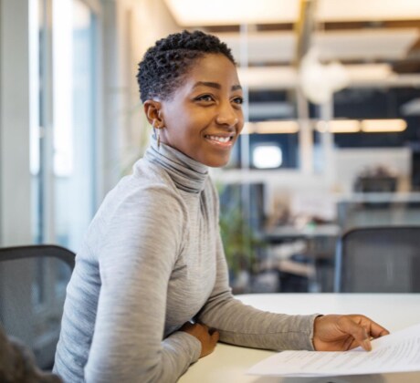 Woman sitting at a table with a piece of paper in hand