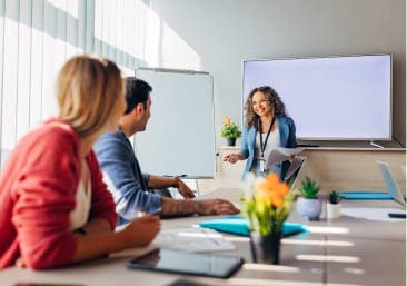 Woman presenting for business colleagues in a conference room.
