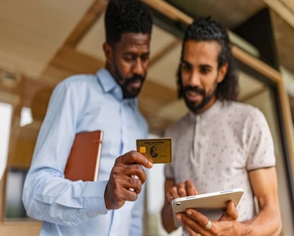 Two businessmen making a purchase on tablet with the Business Gold Card.