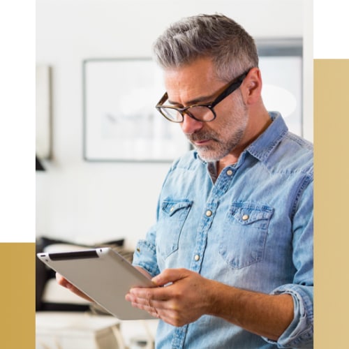 Man holding and looking at tablet.
