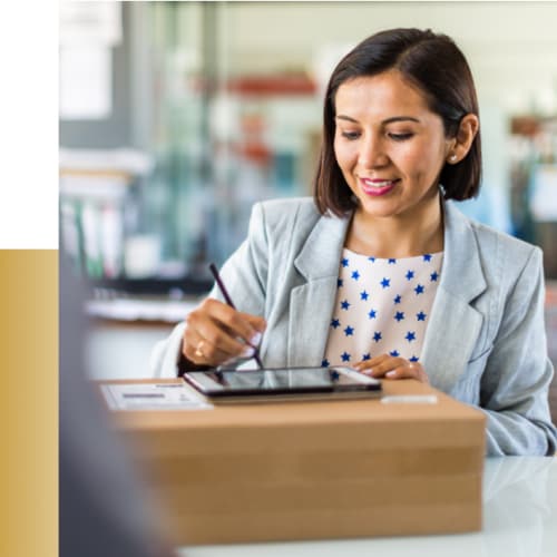 Woman receiving package and signing off on tablet.