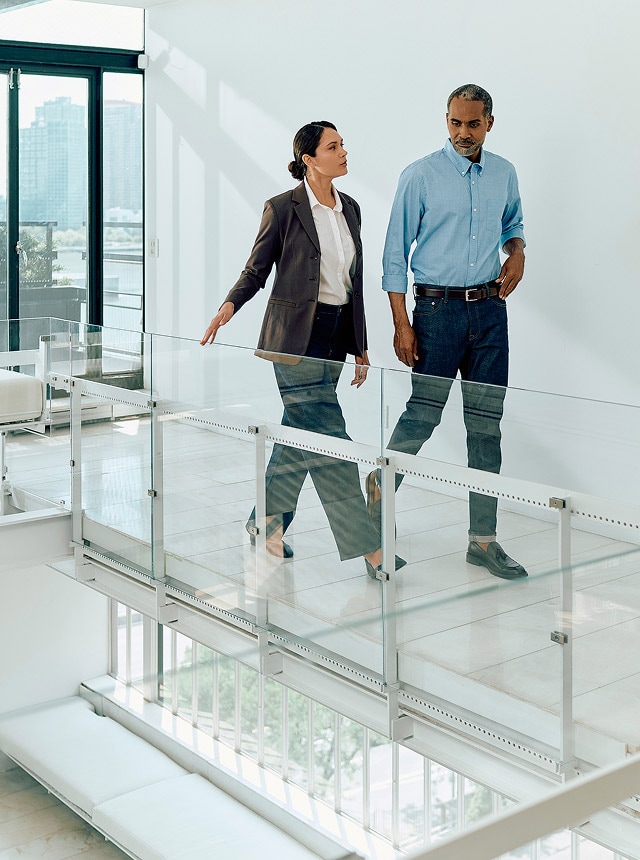 Two coworkers walking in hallway.