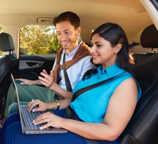 Business woman in a car looking at a tablet