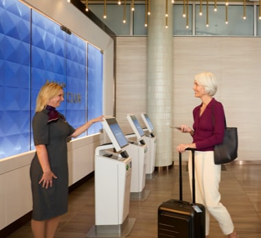 Business woman walking through airport lounge with luggage