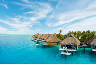Bungalows with thatched roofs nestled in the ocean.