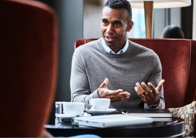Two colleagues reviewing paperwork at an office table.