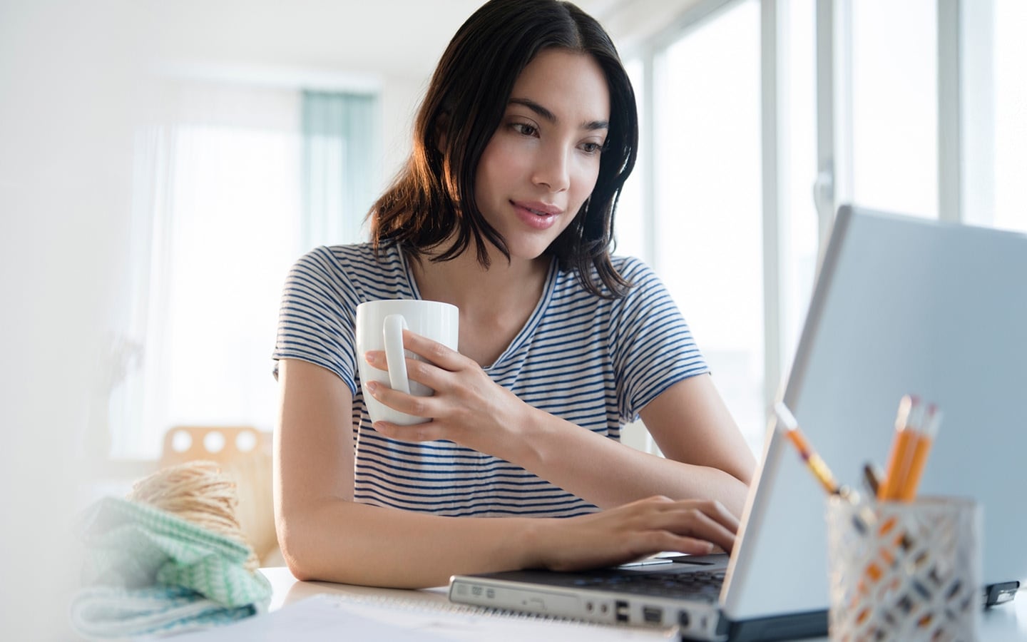 Person on a laptop with a coffee mug