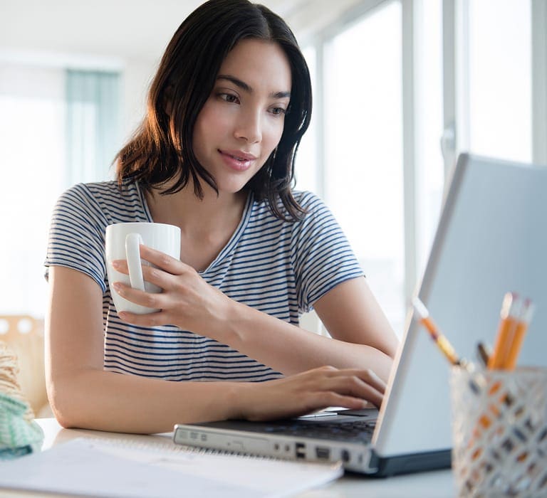 Person on a laptop with a coffee mug