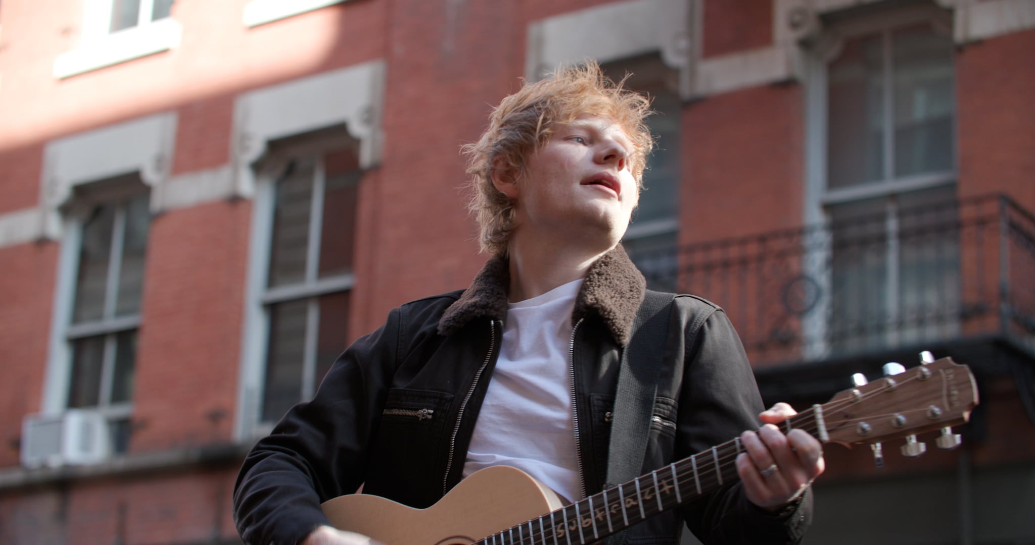 Artist Ed Sheeran playing his guitar 