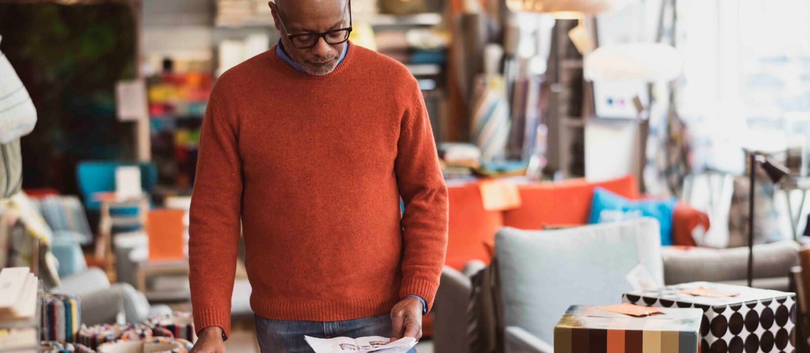 Man is in the department store, looking at the image and searching something on the tablet