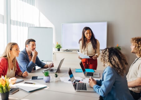 Five people in a boardroom meeting.