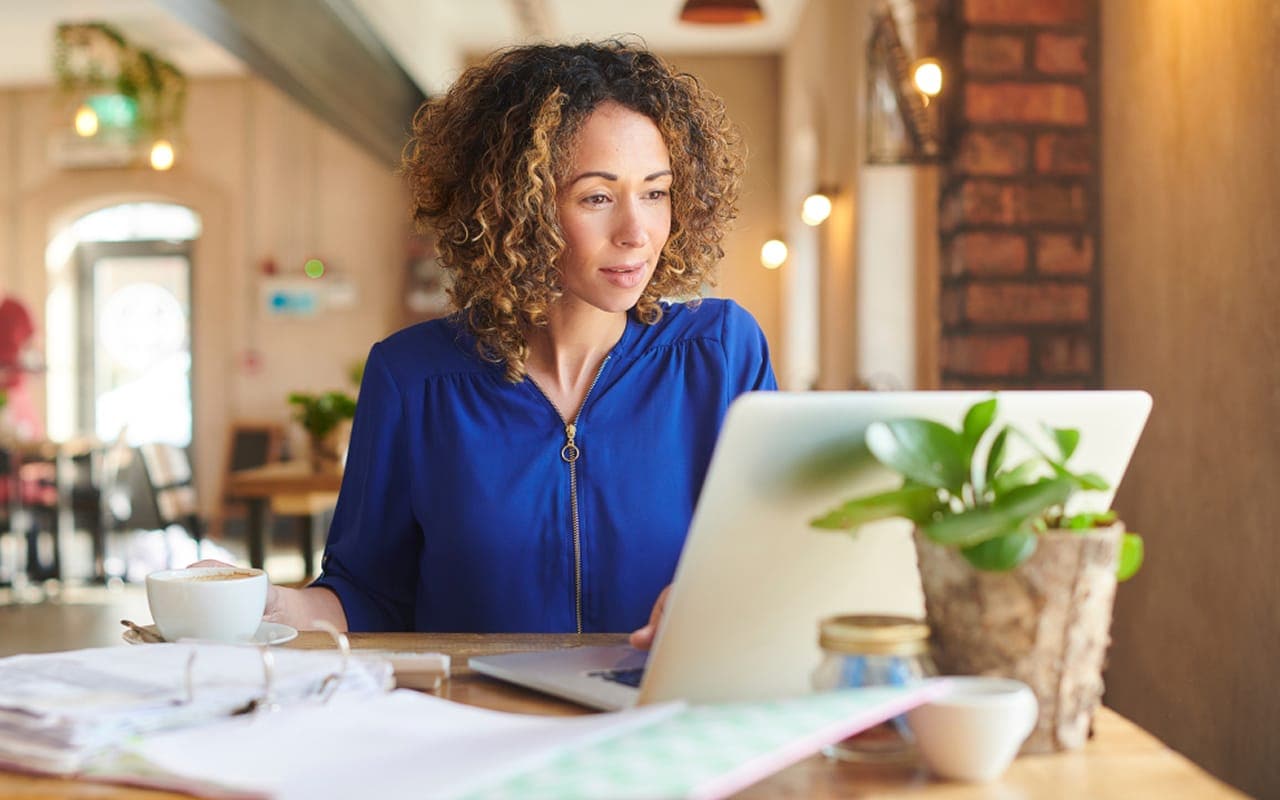A clean, professional image of a person using a laptop to manage finances, with a focus on a digital banking interface.