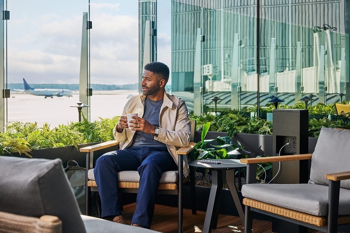 A person relaxing in an airport lounge style chair.