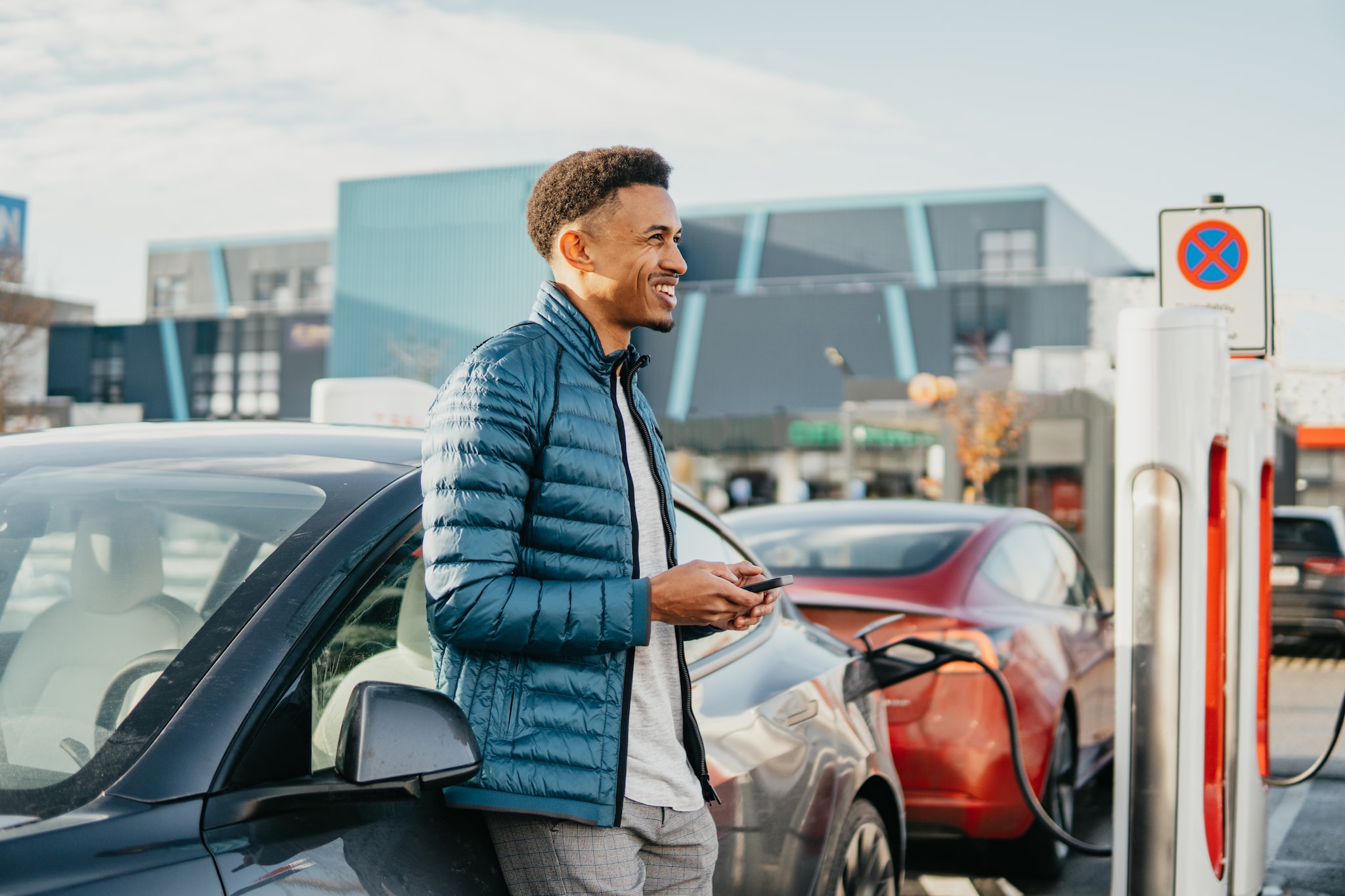 Man is charging an electric car at a charging station