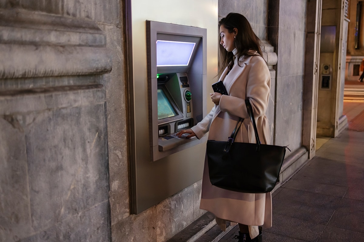 Someone withdrawing cash from an ATM.