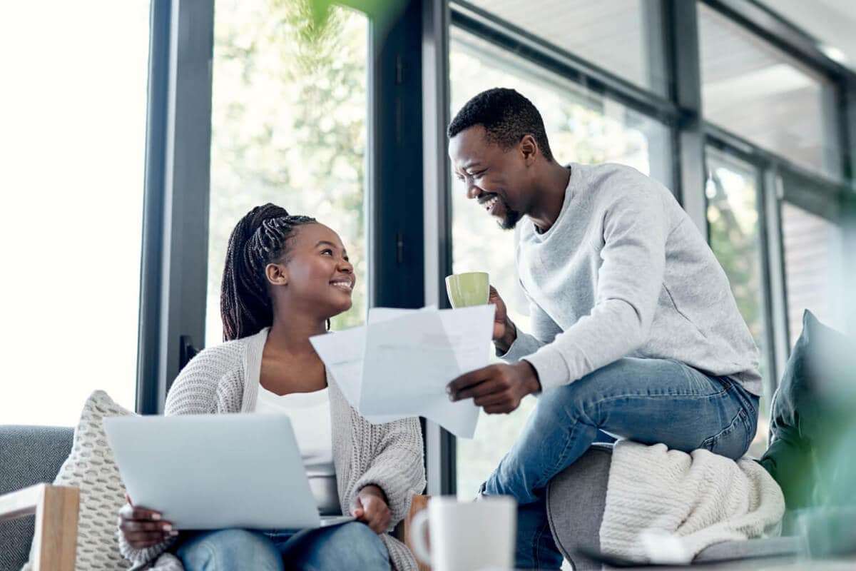 A couple smiling as they log into their online banking account together.