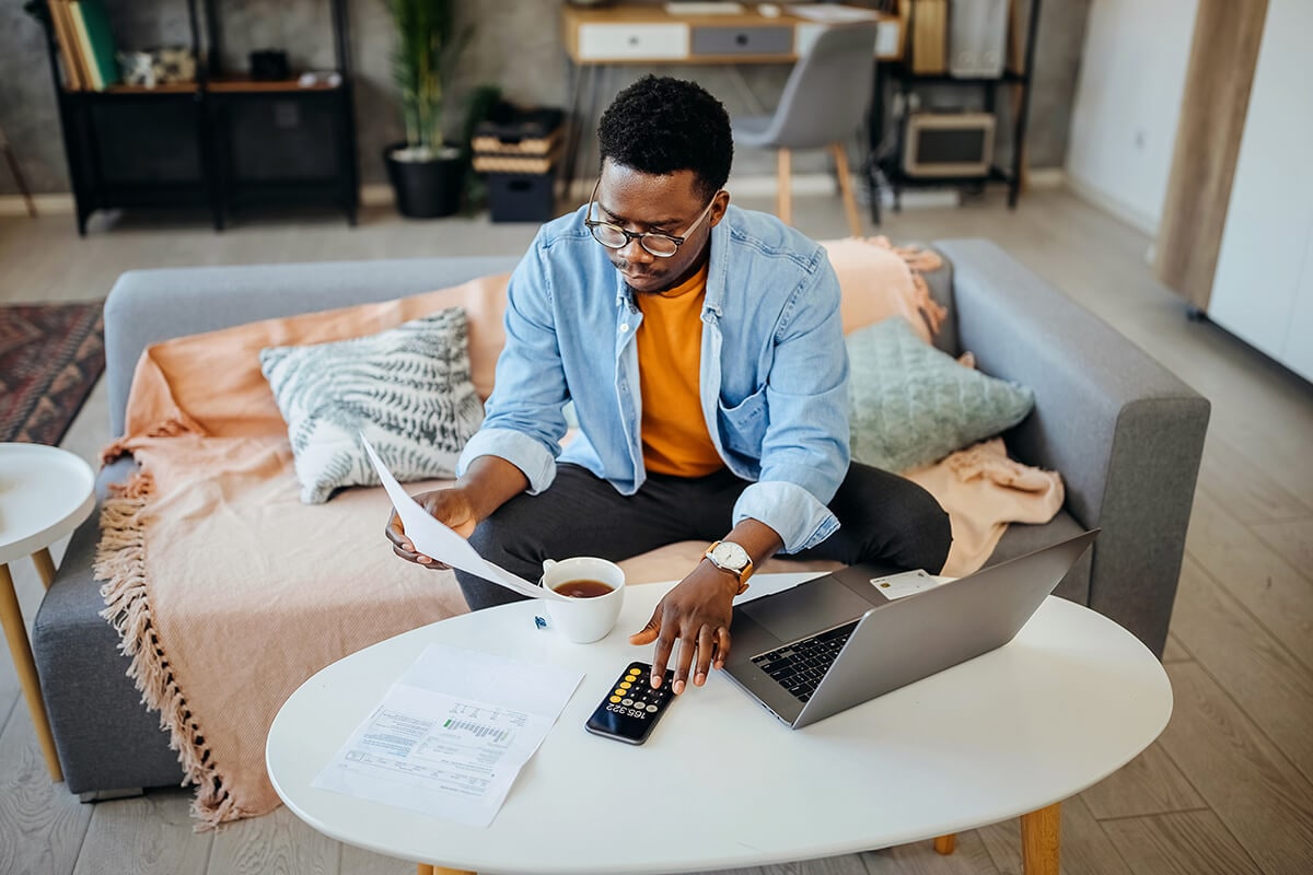 A person reviewing biweekly mortgage payments with a calculator at a desk