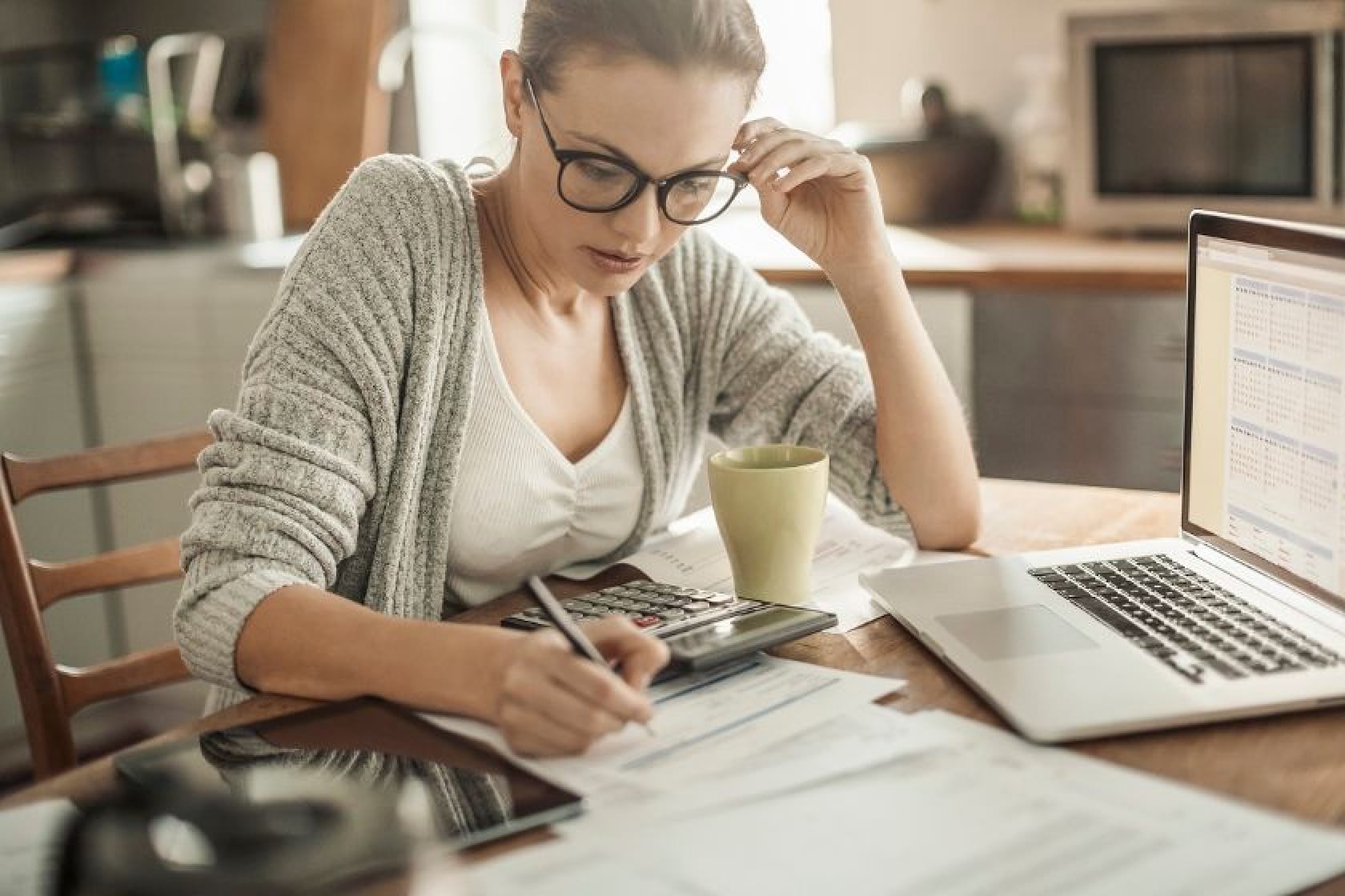 Woman using her laptop at home, representing the shift towards flexible work arrangements in a cozy setting.