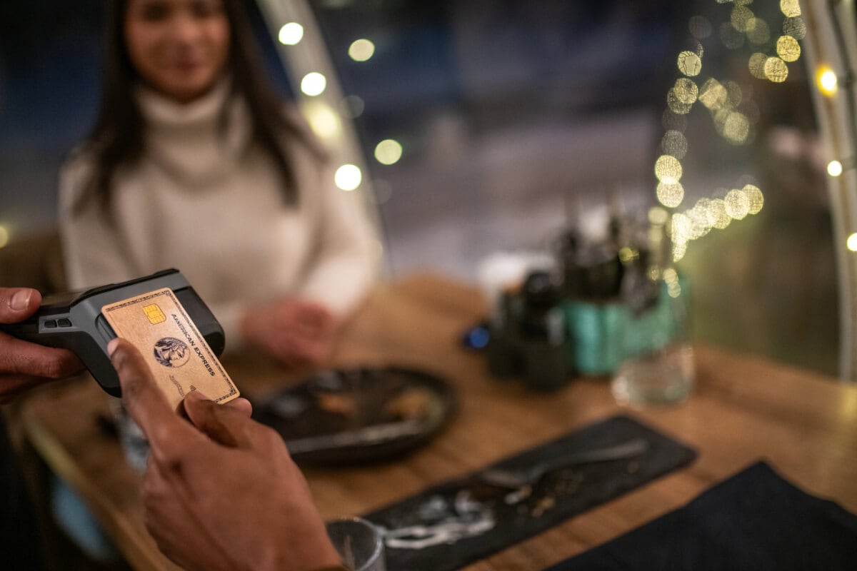 Someone swiping or tapping a card to pay.