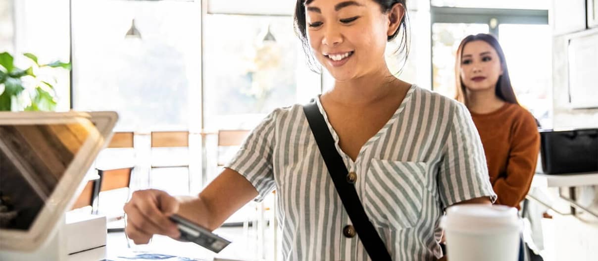 A person using their debit card to make a purchase at a shop