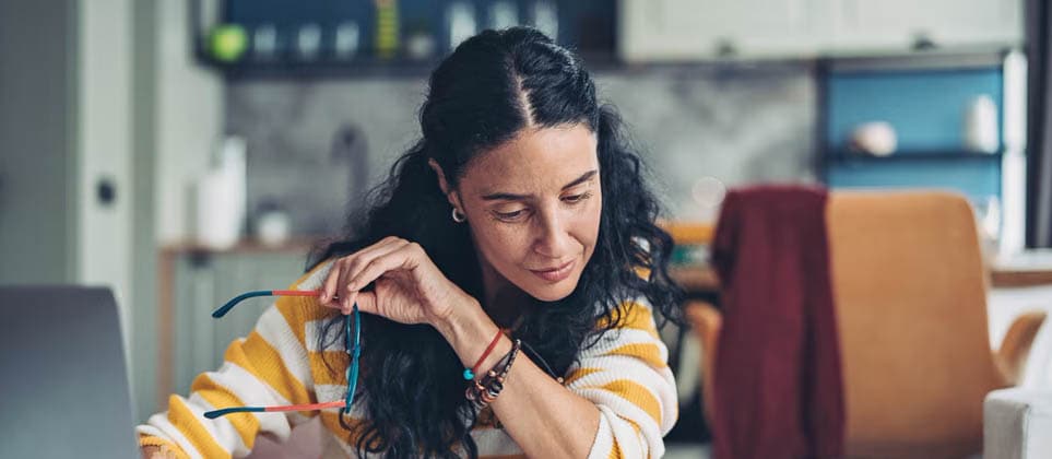 A woman reviewing the certificate of deposit with a laptop on the desk.