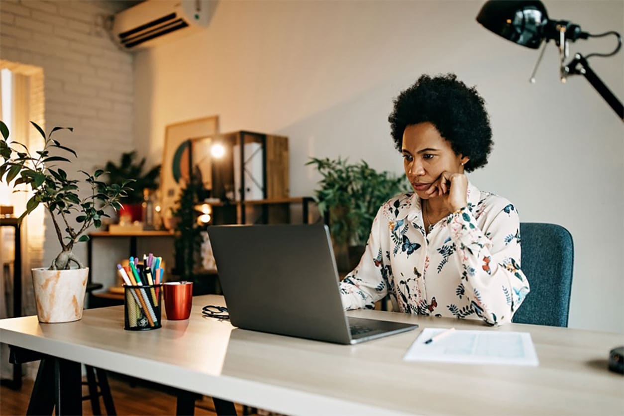 A woman using her laptop while sitting at her desk