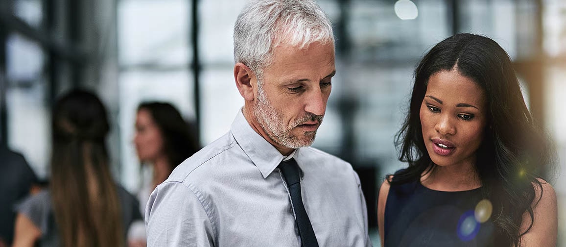 Two people discussing something displayed on a smart device.