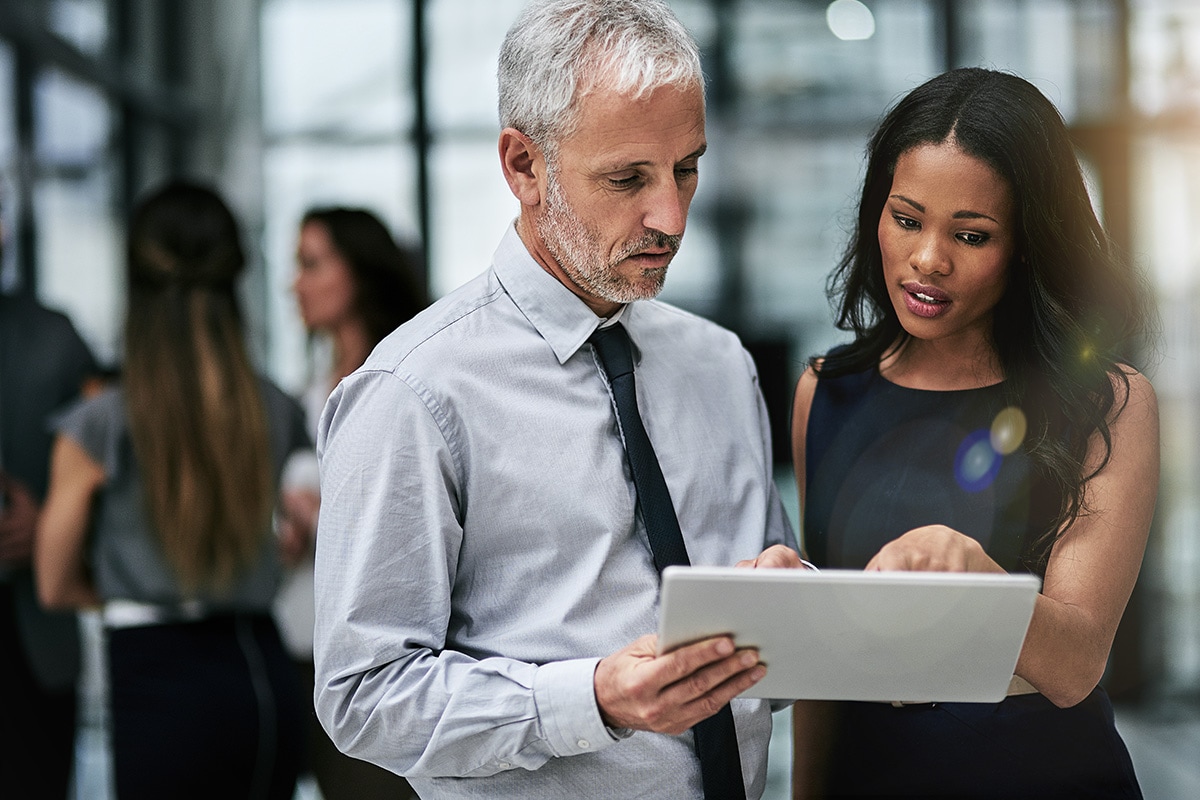 Two people discussing something displayed on a smart device.