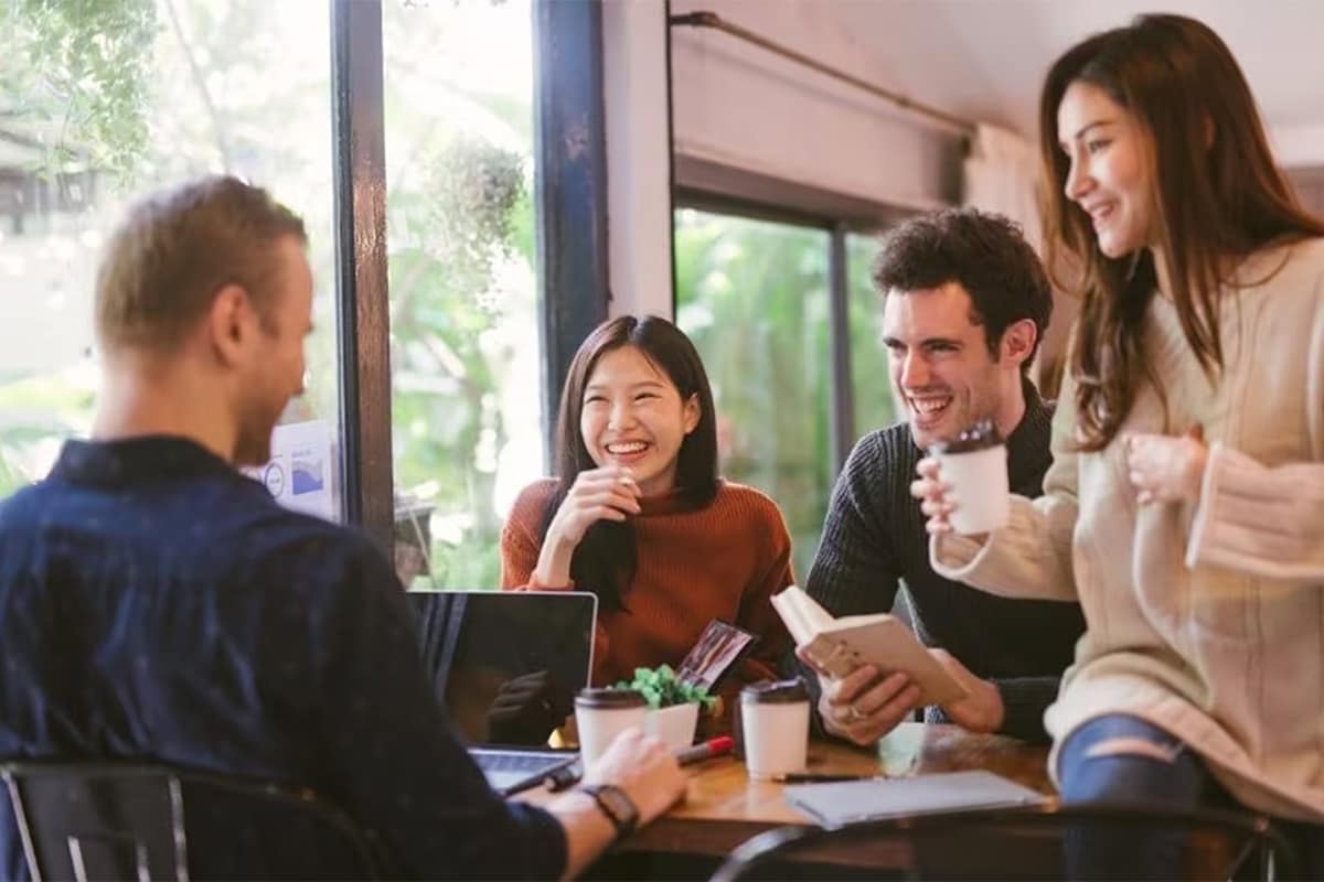 Two women and two men are hanging out at the coffee shop