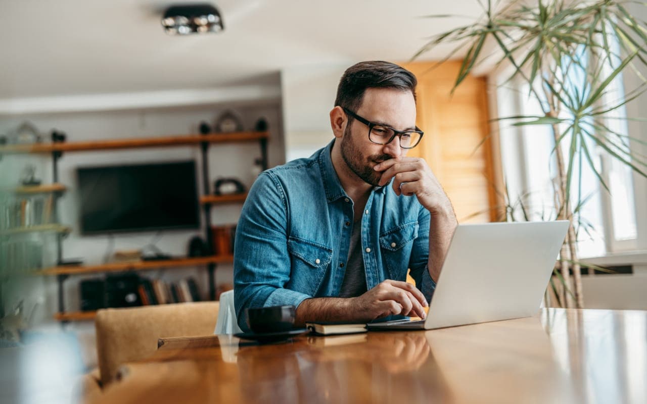 A professional image of a person reviewing their credit card statement on a laptop.