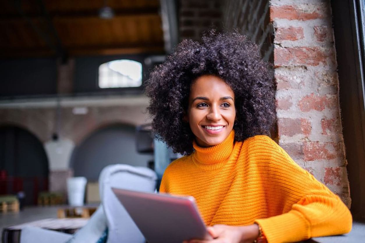 A happy woman with an iPad, symbolizing the diverse options for credit protection and financial safety.
