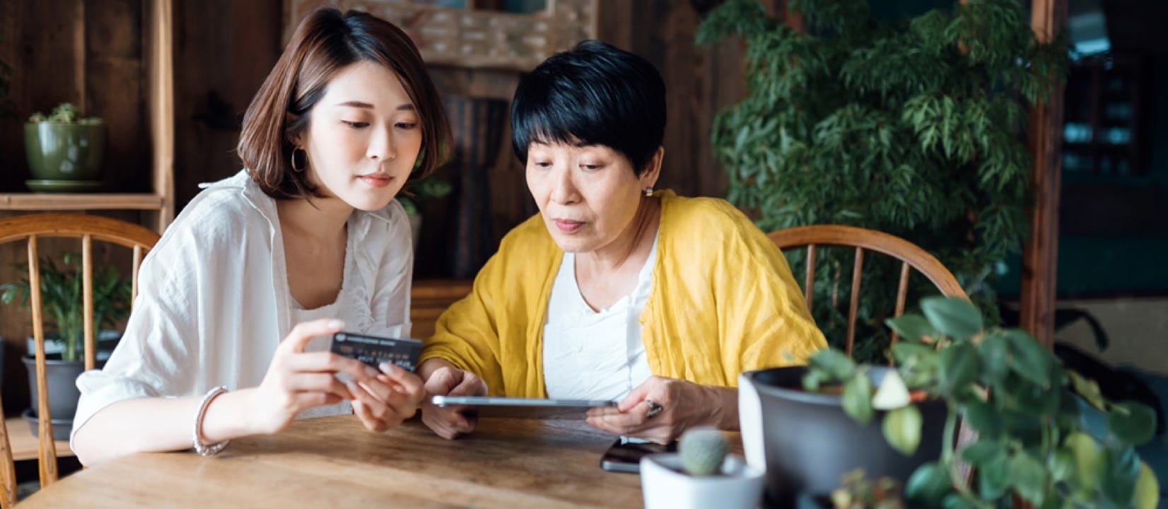 Two women registering their credit card online via their tablet