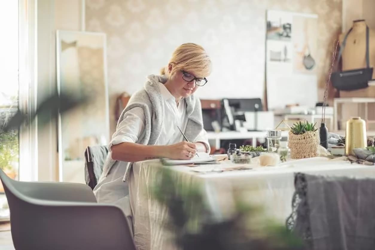 Woman sitting at a table writing notes