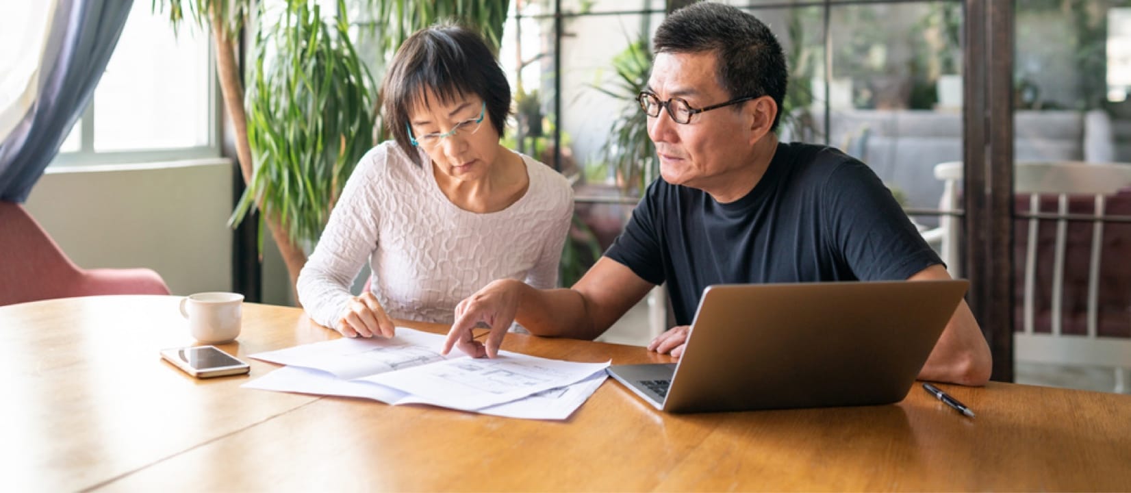A couple at a table with a laptop and documents on diy credit repair