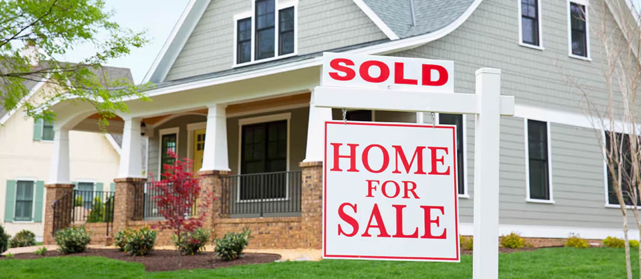 A sold sign prominently displayed in front of a house, symbolizing successful real estate transactions and equal opportunity housing.