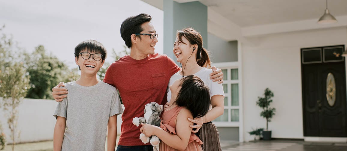 A family standing before their home, exuding warmth and unity