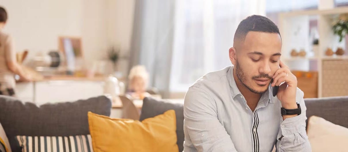 Man talking on the phone while taking notes
