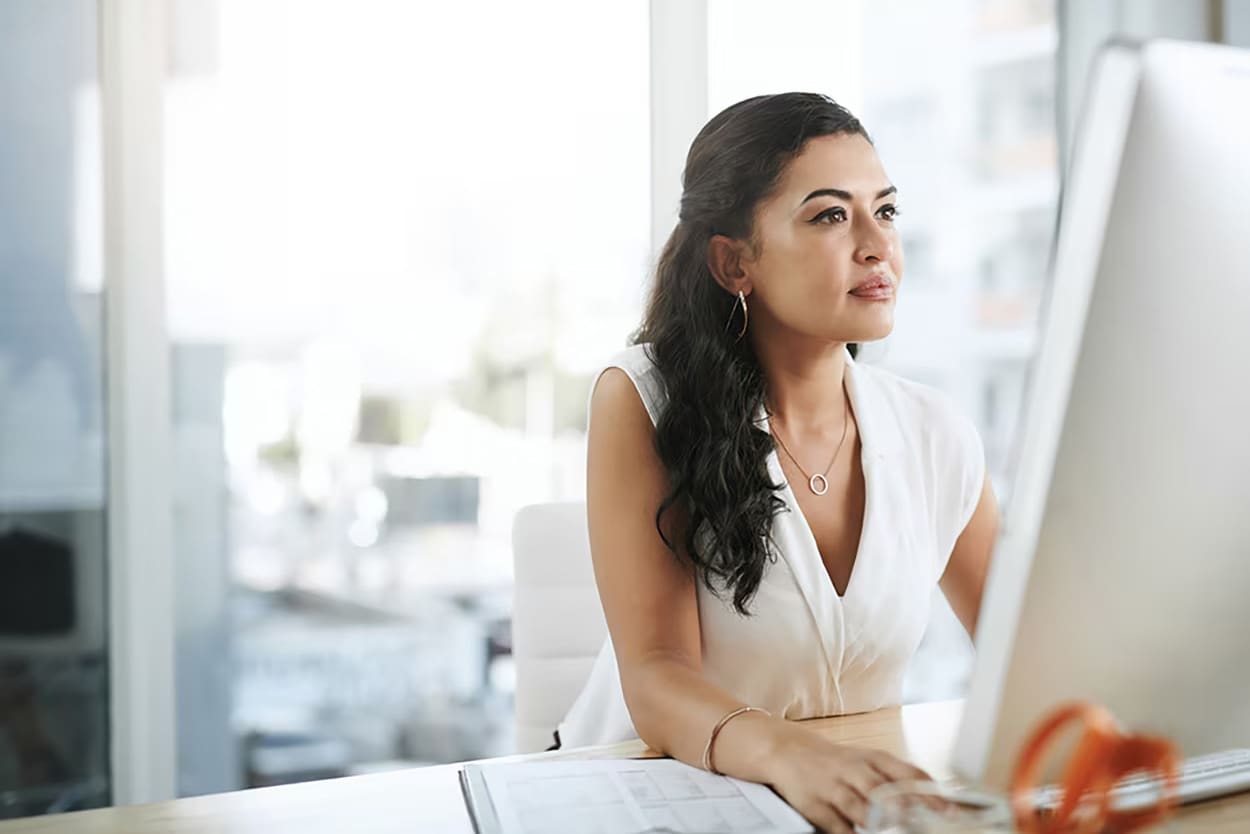 Woman looking at her computer at her desk