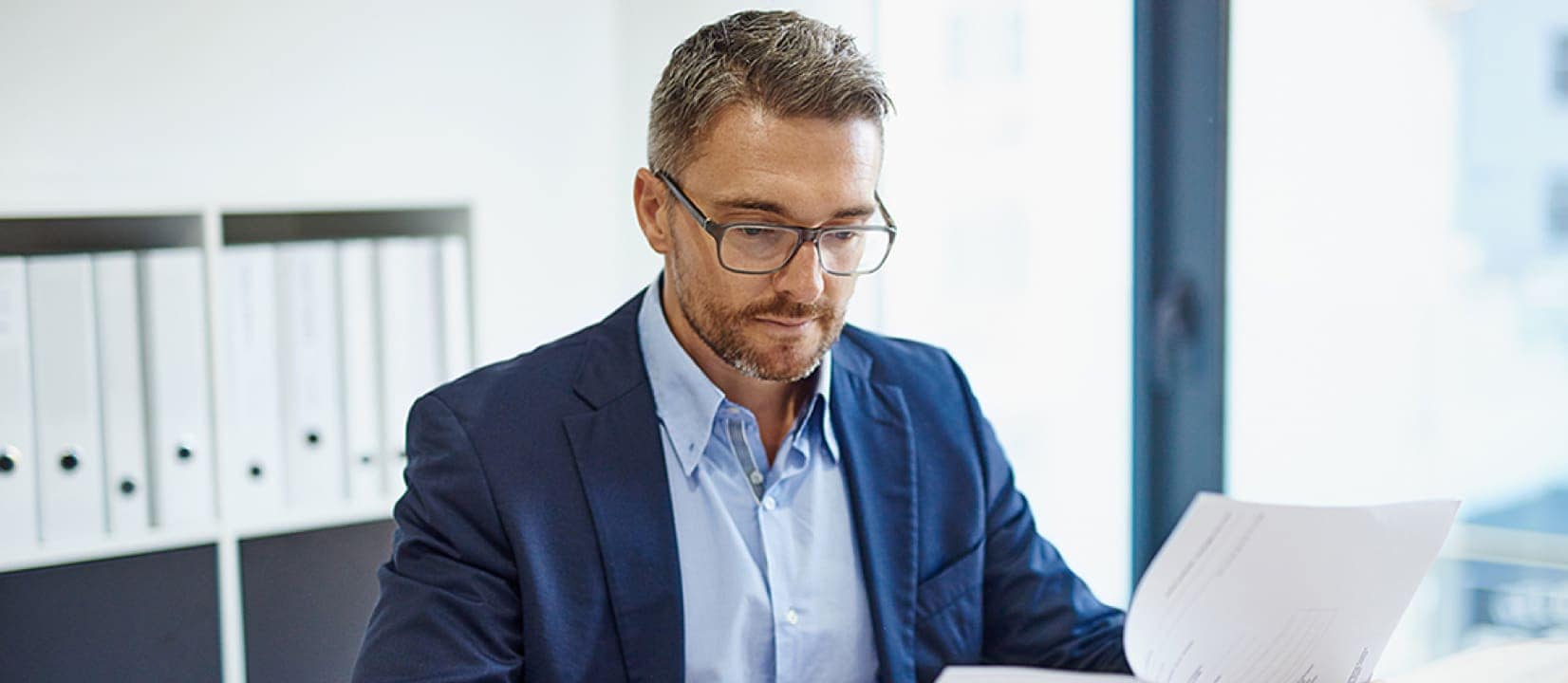 A person sitting at a desk organizing paperwork.