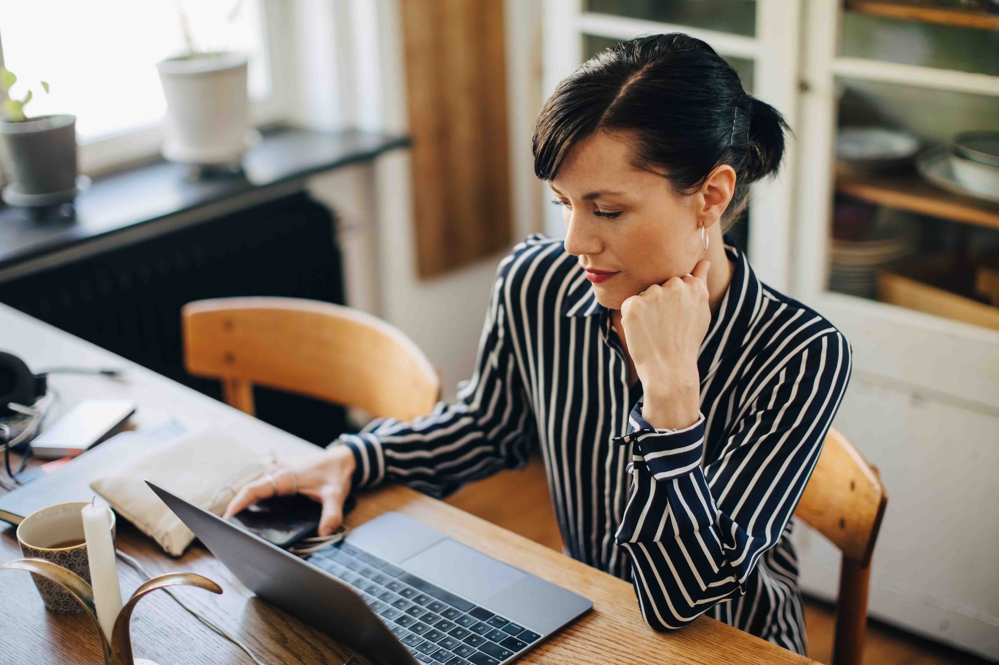 A woman uses her laptop while sitting at her desk