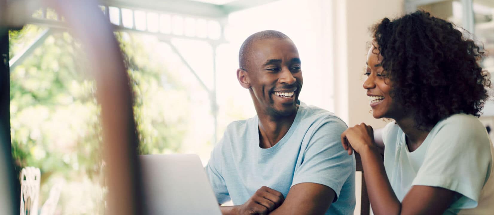 Man and woman are sitting and smiling in the room