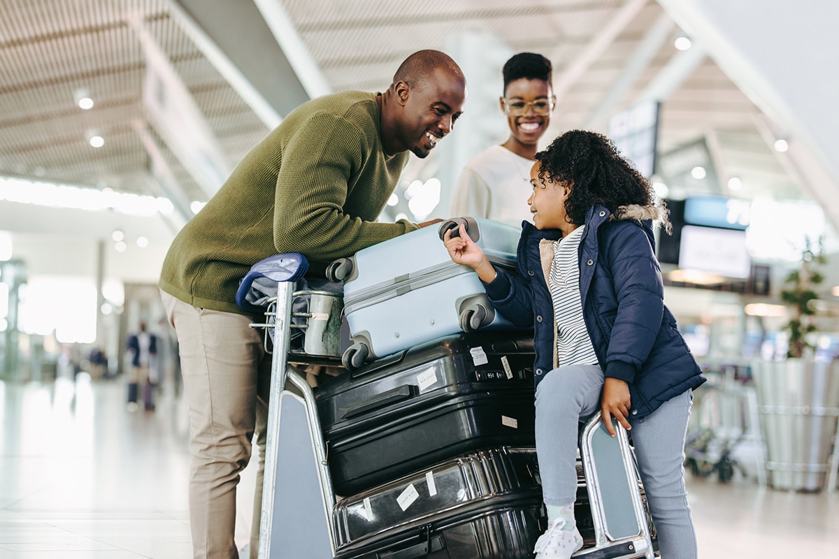 A family enjoying themselves in an airport while traveling.