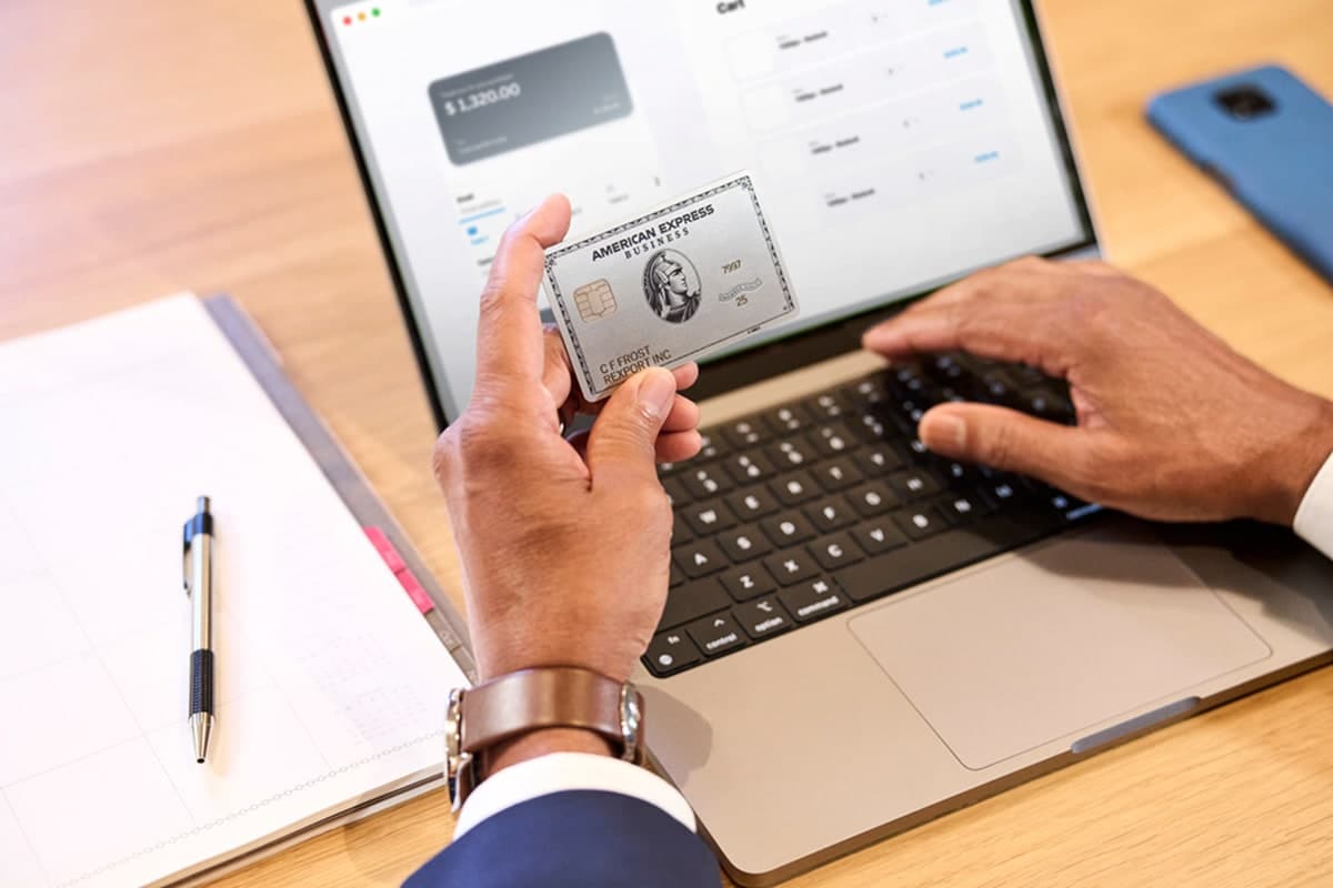A professional image of a person sitting at a desk, reviewing multiple account balances on a laptop.