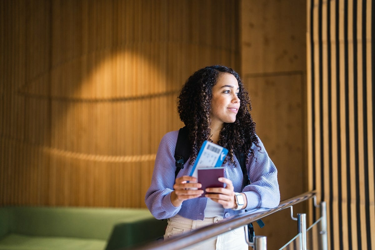 A professional image of a traveler at an airport, holding a passport and boarding pass, with a confident and prepared expression, evoking security and peace of mind.